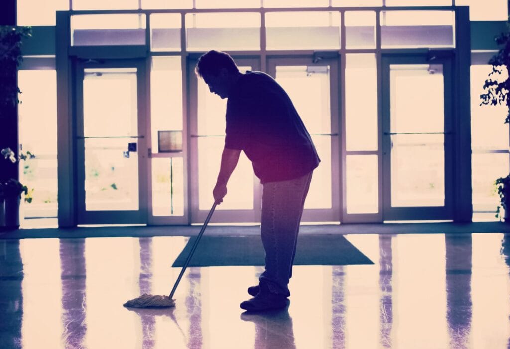 Janitor providing commercial janitorial services in an office building