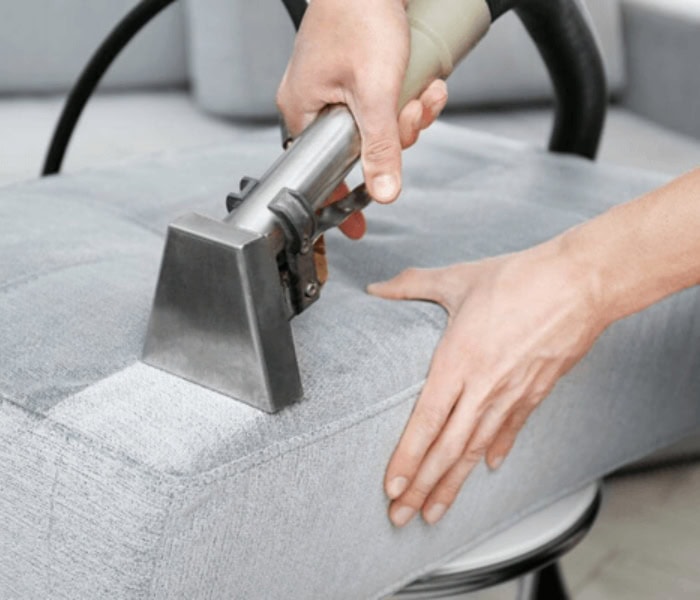 Canadian Carpet Cleaning staff steam cleaning a couch
